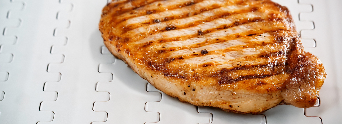 Chicken breast moving on a poultry conveyor system belt during processing