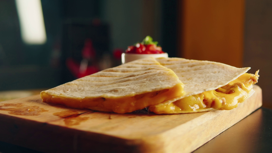 close-up-of-cheese-quesadilla-eating-traditional-mexican-food-tex-mex-cuisine-hands-ta